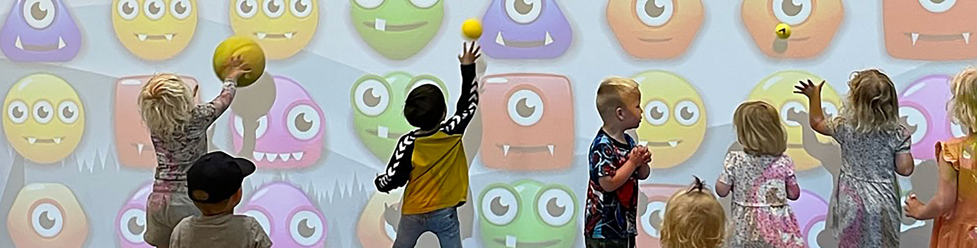 Børn spiller boldspil på den interaktive multiball-væg i Hirtshals Idrætscenter