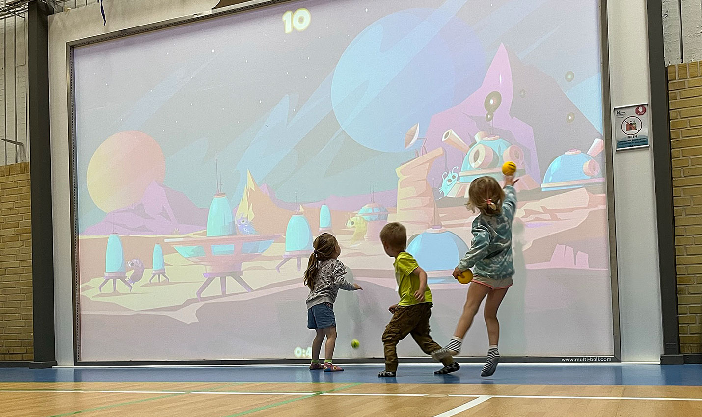 Børn spiller boldspil på den interaktive multiball-væg i Hirtshals Idrætscenter.