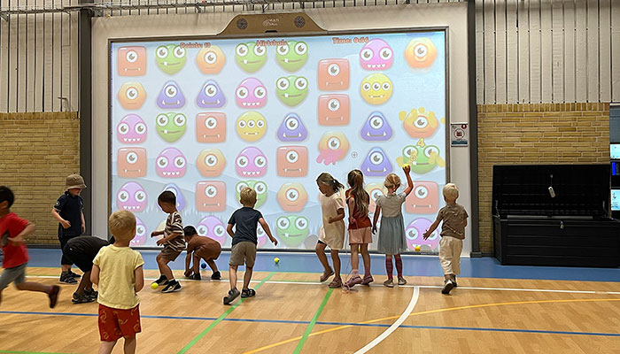 Børn spiller sjove boldspil på den interaktive multiball-væg i Hirtshals Idrætscenter.