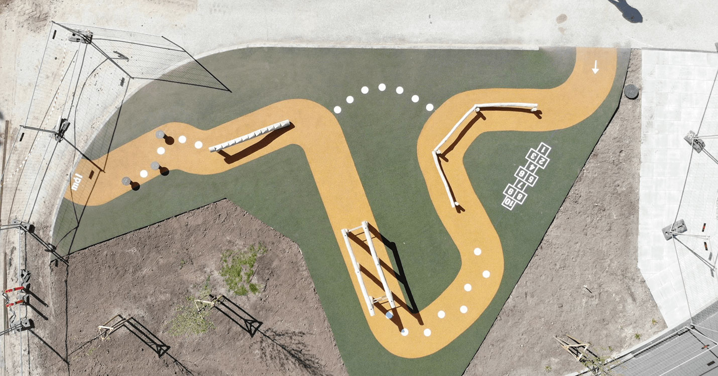 Udendørs bevægelsesmiljø ved Gistrup Skole med en stor forhindringsbane med et underlag af gummibelægning.