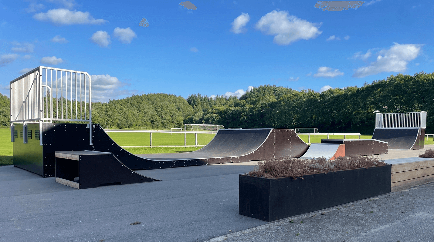 En mindre udendørs skatepark med skate ramper.