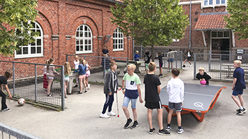 Elever i skolegården spiller bordfodbold, teqball og boldspil 