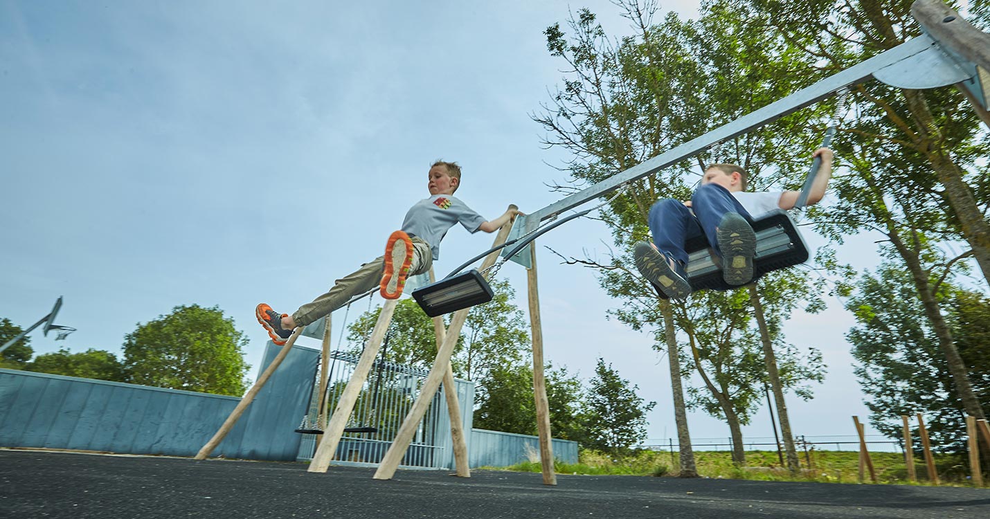 Drenge hopper af gyngen