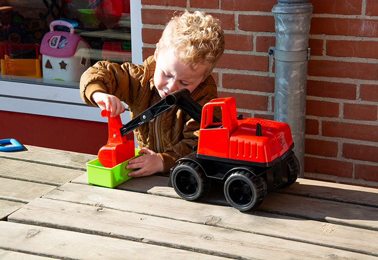 Dreng leger med sandlegetøj