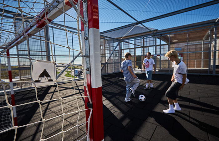 Drenge spiller fodbold i boldbur